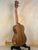 Wooden tenor acacia ukulele with grain patterns on a stand in a beginners bundle