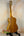 Wooden acoustic guitar on black stand in Tenor Mango Ukulele Beginners Bundle setup