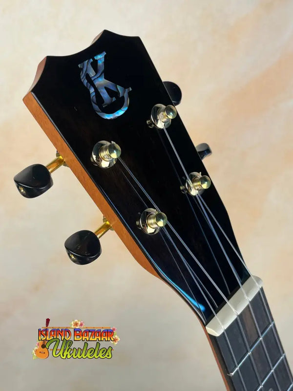 Guitar headstock with black finish and gold tuning pegs on Kanile’a KPA Premium Tenor Ukulele