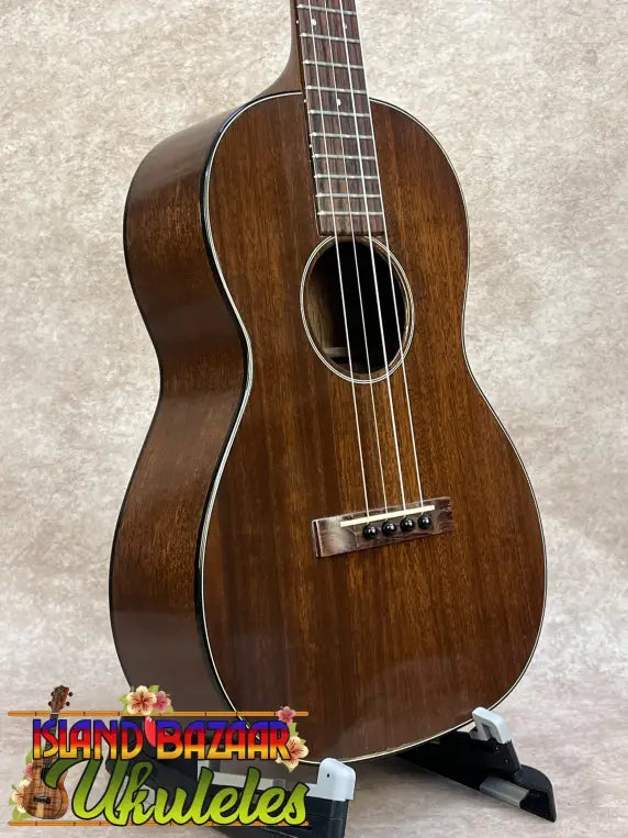 A polished dark brown vintage martin custom baritone ukulele with glossy finish and white binding edges with case